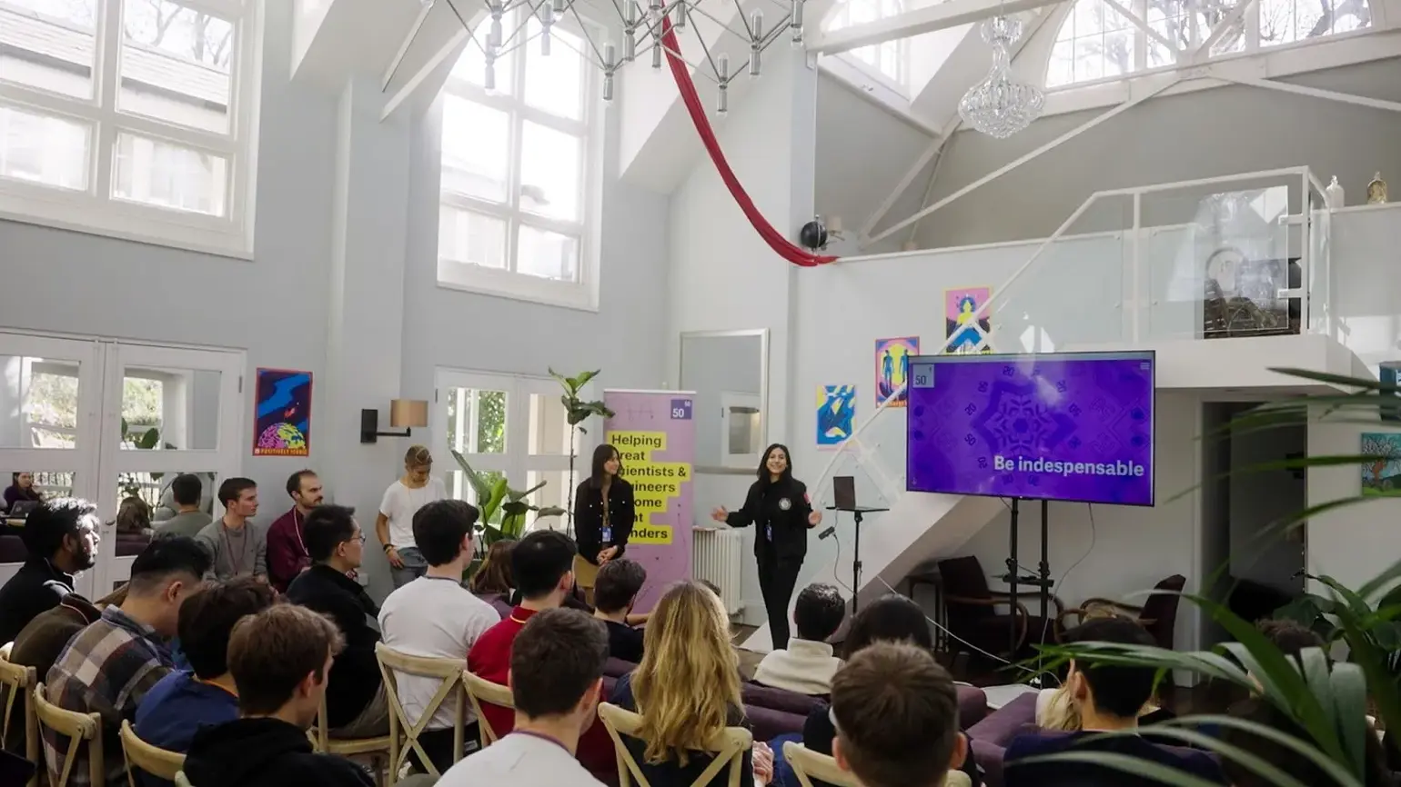A group of people watching a talk at the 5050 Cohort 1 kick-off event