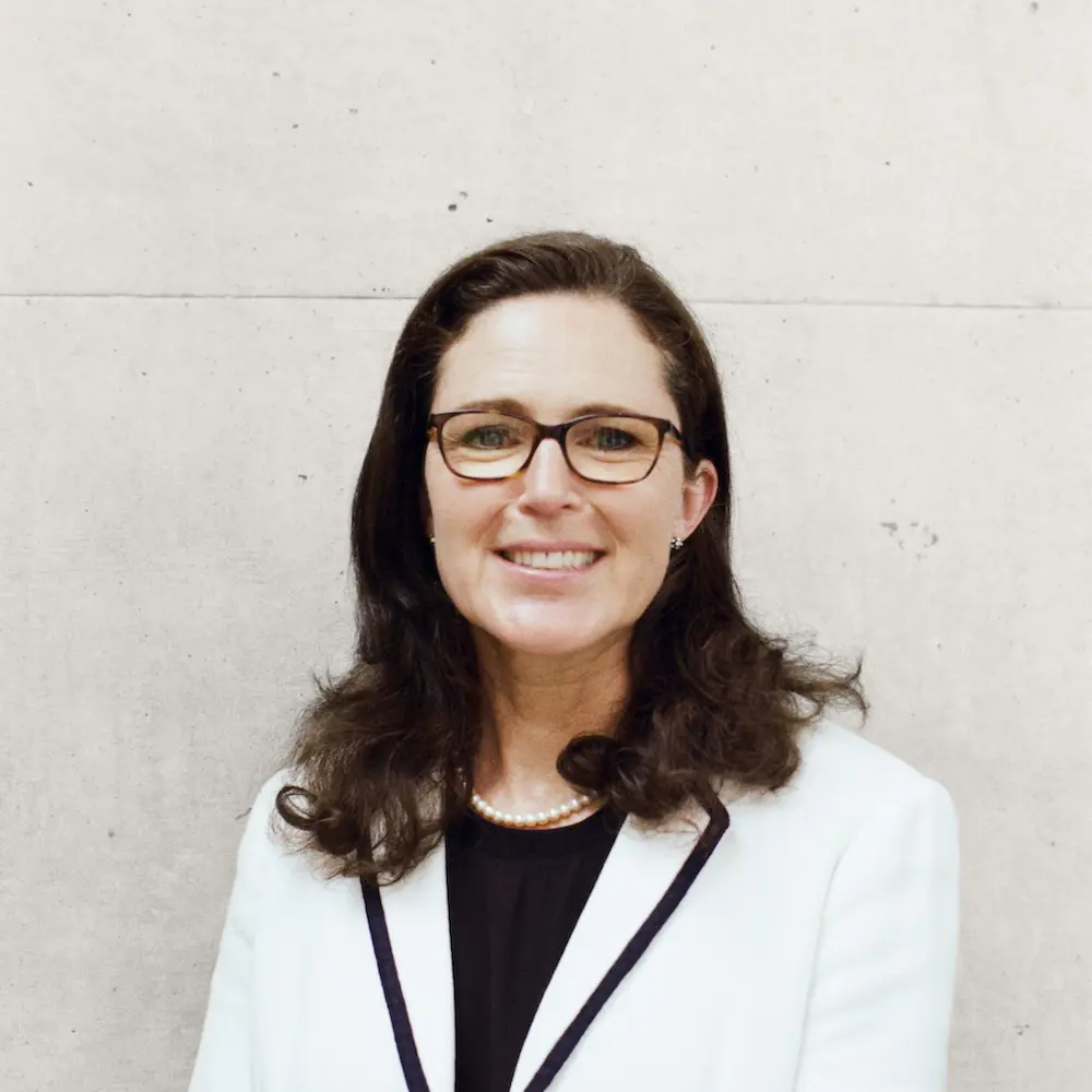 Headshot of Antonia Jenkinson standing in front of a white wall