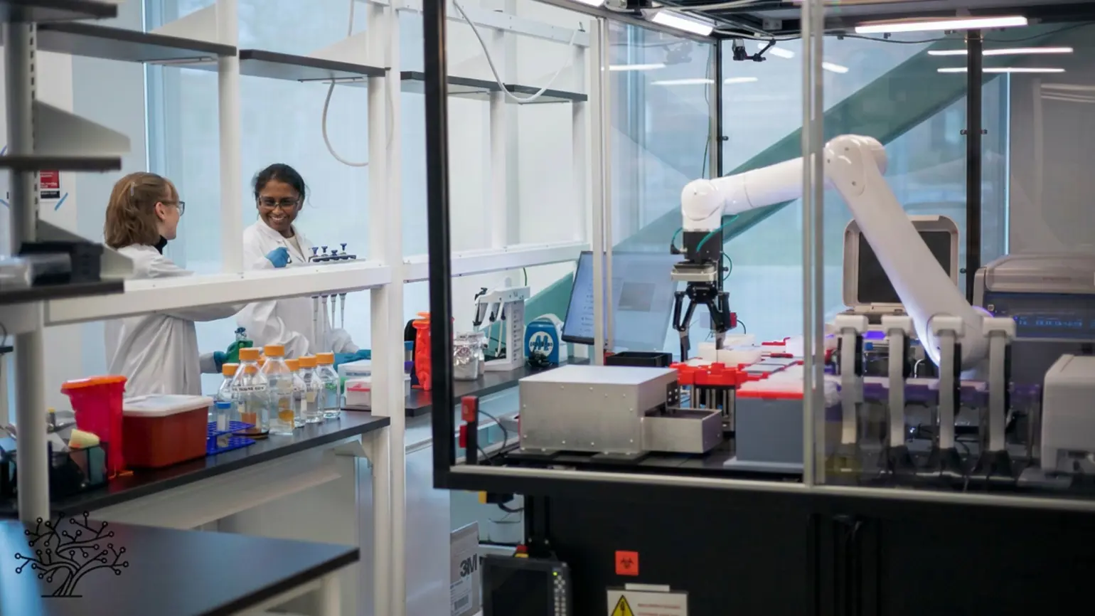 Two women working in a lab with a large robot