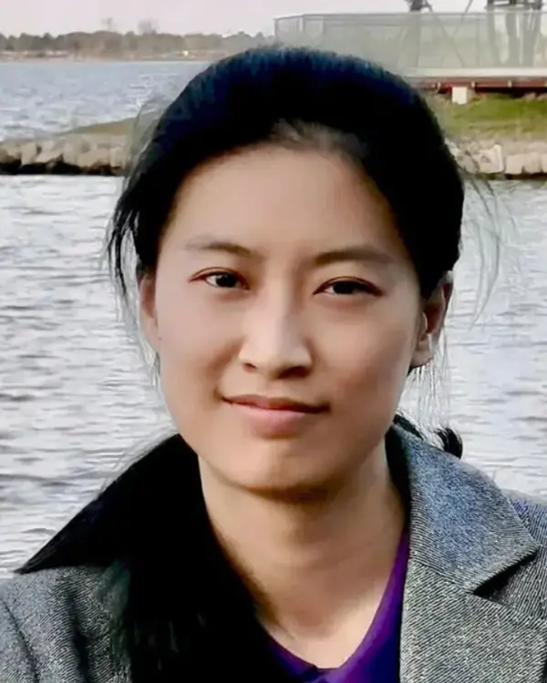 A photo of Creator Kirsty Wan standing in front of a lake