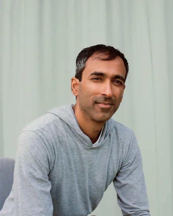 A photo of Suraj Bramhavar in front of a blue curtain.