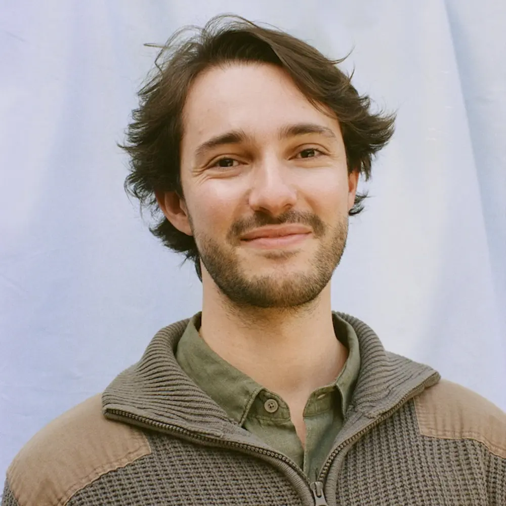 Photo of Alex Obadia smiling against a blue background