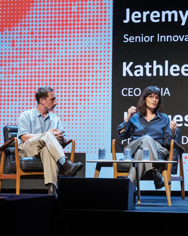 Jacques Carolan and Kathleen Fisher sitting on stage in discussion with Jeremy White from Wired Health