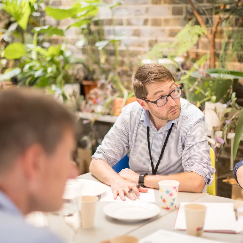 A photo of Mark Symes in conversation at an event. 