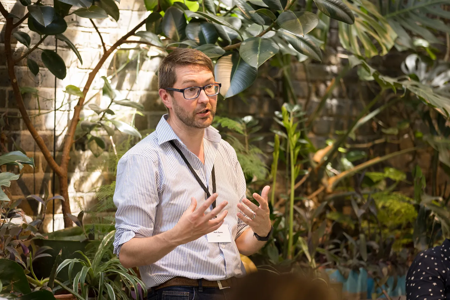 A photo of Mark Symes speaking at an event.