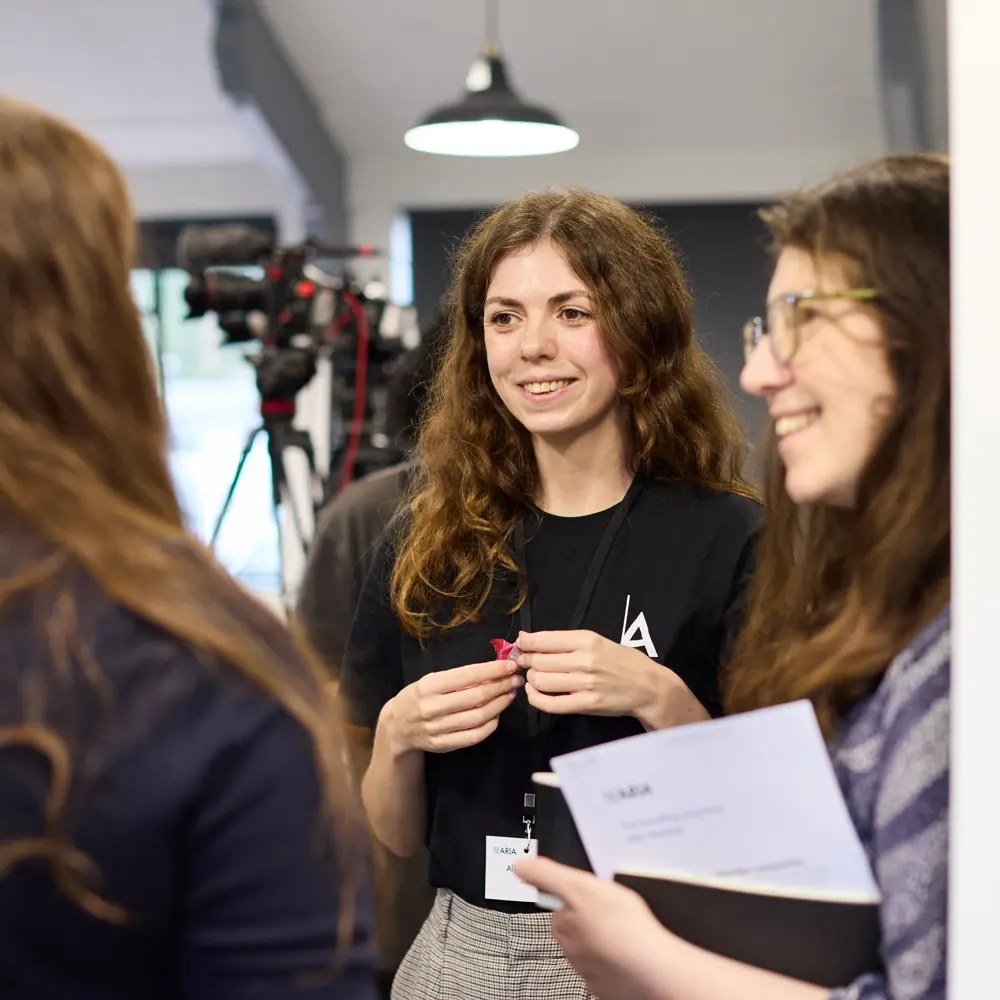 Three women standing in an office having a discussion