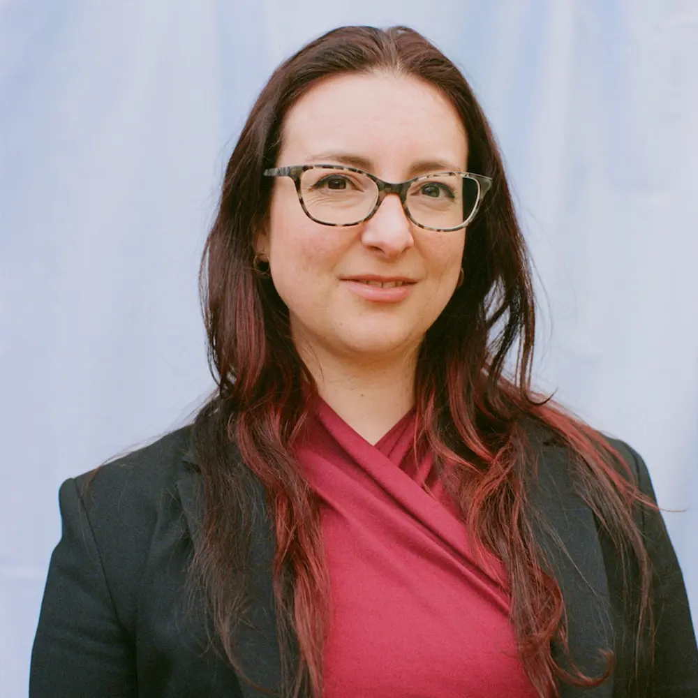 Photo of Nicole Wheeler smiling in front of a blue background