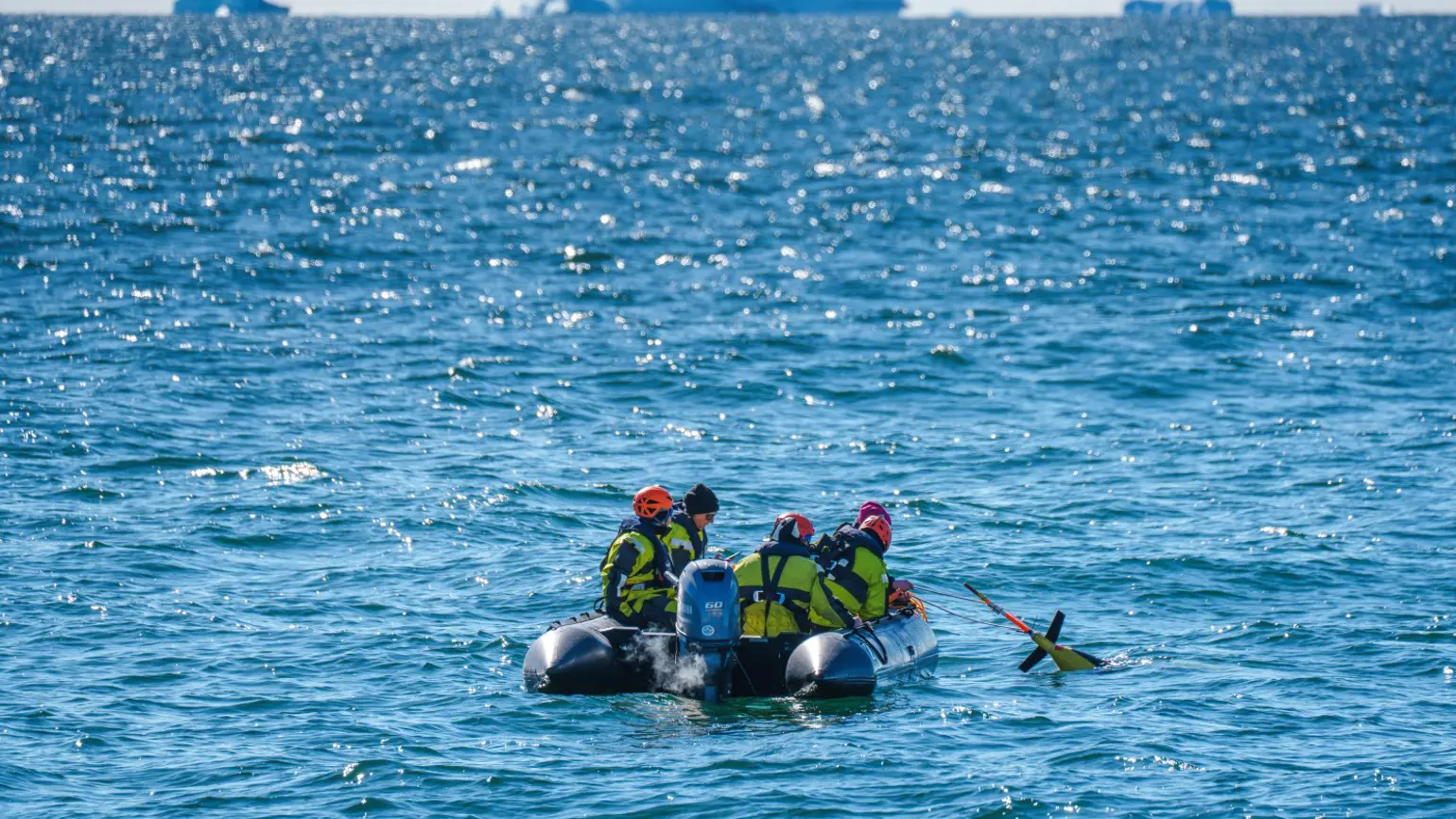 A team of scientists and crew members deploy an underwater glider in Antarctica.